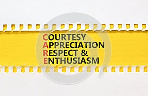 CARE symbol. Concept words CARE courtesy appreciation respect and enthusiasm on yellow paper on beautiful white background.