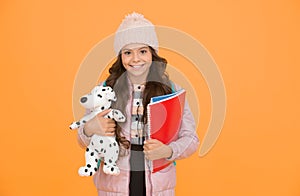 Care and treatment of animals. Studying veterinary medicine. Happy child hold toy dog and books. Little girl smile with