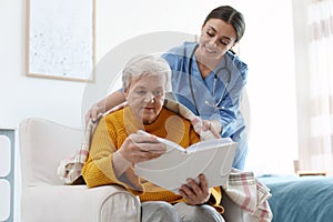 Care worker covering elderly woman with plaid in hospice