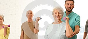 Care worker helping elderly woman to do exercise with dumbbell in gym. Banner design