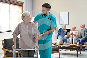 Care worker helping to elderly woman with walker in hospice