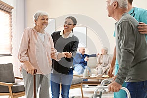 Care workers helping to elderly patients to walk in hospice