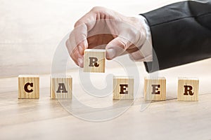 Career adviser assembling the word career with six wooden cubes