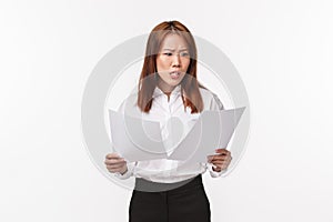 Career, business and women concept. Portrait of concerned and anxious office lady panicking as reading documents