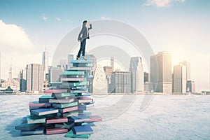 Career and education concept with businesswoman on book mountain looking into the distance