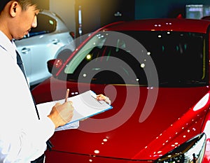 Career man saleman business inspection writing on notepad or book, paper with car blurry background.for transport automobile autom photo