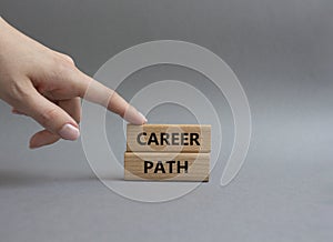 Career path symbol. Concept word Career path on wooden blocks. Beautiful grey background. Businessman hand. Business and Career