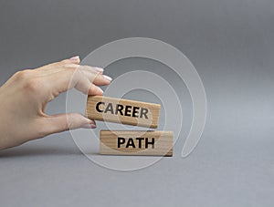 Career path symbol. Concept word Career path on wooden blocks. Beautiful grey background. Businessman hand. Business and Career