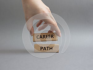 Career path symbol. Concept word Career path on wooden blocks. Beautiful grey background. Businessman hand. Business and Career