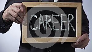 Career written on blackboard, business person holding sign, motivation, future