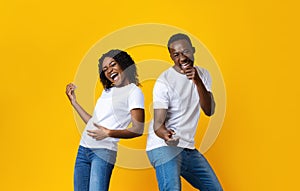 Carefree african american couple having fun on yellow