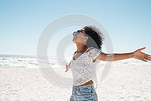 Carefree african american woman at beach with outstretched hands