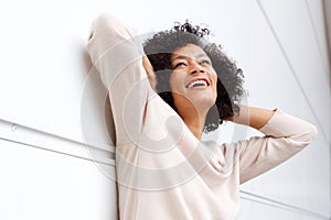 Carefree african american woman smiling with hands behind head