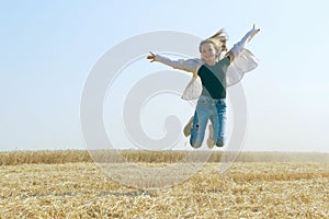 Carefree and attractive young woman in a wheat field. People, nature, farming concept.