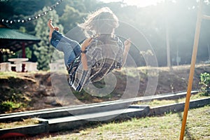 Carefree barefoot girl on swing in sun light