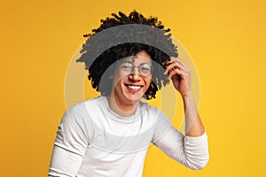 Carefree black guy in glasses with bushy hairstyle laughing