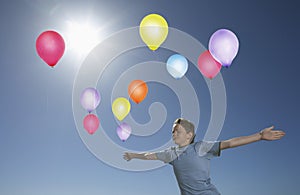 Carefree Boy In Midair With Colorful Balloons photo