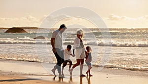 Carefree caucasian family walking together on the beach in the morning. Parents spending time with their son and