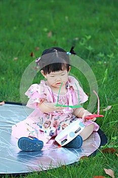 Carefree Chinese baby girl play on the lawn