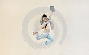 Carefree chinese man with computer in his hand jumping up