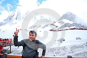 Carefree Chinese man on Yunnan Jade dragon snow mountain,A gesture of victory