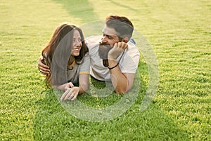 Carefree couple enjoying sunny day relaxing on green meadow, romantic date concept