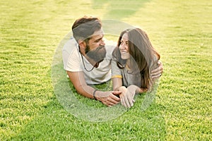 Carefree couple enjoying sunny day relaxing on green meadow, love from first sight concept