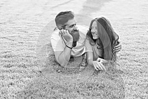 Carefree couple enjoying sunny day relaxing on green meadow, romantic date concept