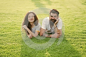 Carefree couple enjoying sunny day relaxing on green meadow, summer vacation concept