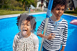 Carefree Delight: Close-Up of Afro-American Boy and Girl, Girl Playfully Sticking Out Tongue
