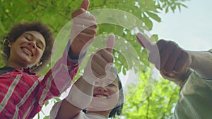 Carefree diverse multicultural young people showing thumbs up outdoor