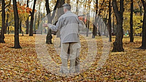 Carefree elderly caucasian grandparents family dancing romantic dance together in autumn park happy aged older couple