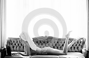 Carefree female model, sensual woman using computer on bed in apartment or hotel room. Morning rest chill.