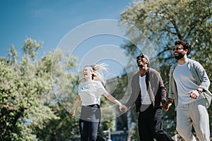 Carefree friends laughing and walking together in a sunny urban park