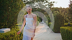 Carefree girl spinning park walk looking camera with happy smile. Woman smiling