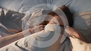 Carefree girl stretching bed in sunlight closeup. Happy female waking up early