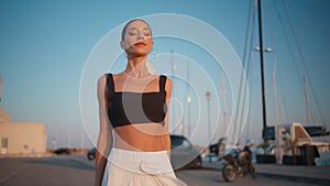 Carefree girl walking promenade summer evening. Gorgeous woman enjoying sunlight