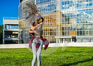 Carefree girl with zizi cornrows dreadlocks dancing on green lawn