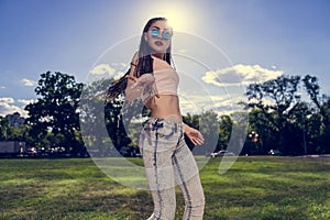 Carefree girl with zizi cornrows dreadlocks dancing on green lawn