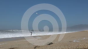 Carefree happy boy flying kite on ocean beach