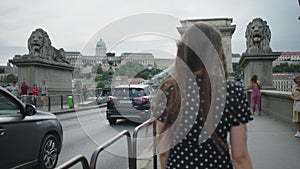 Carefree happy girl running along Chain Bridge in Budapest,