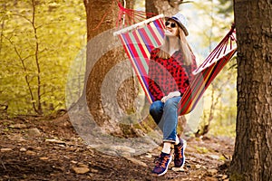 Carefree happy woman lying on hammock enjoying harmony with nature. Freedom. Enjoyment. Relaxing in forest.