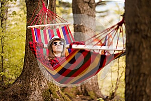 Carefree happy woman lying on hammock enjoying harmony with nature. Freedom. Enjoyment. Relaxing in forest.