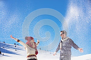 Carefree happy young couple having fun together in snow.