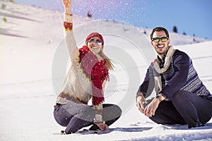 Carefree happy young couple having fun together in snow.