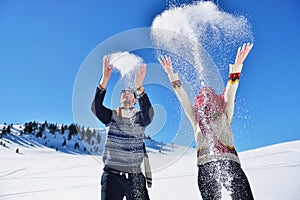 Carefree happy young couple having fun together in snow.