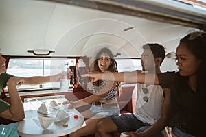 Carefree hipster having fun with cheers inside retro van