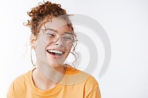 Carefree joyful happy young lucky redhead girl wearing glasses messy curly bun haircut laughing adore awesome funny