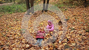 Carefree kids playing in a pile of fall leaves