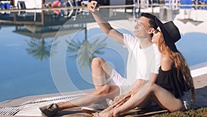 Carefree lovers resting near swimming pool. Couple on vacation, sunbathing, relaxing. Vacation, tourism, hooneymoon.